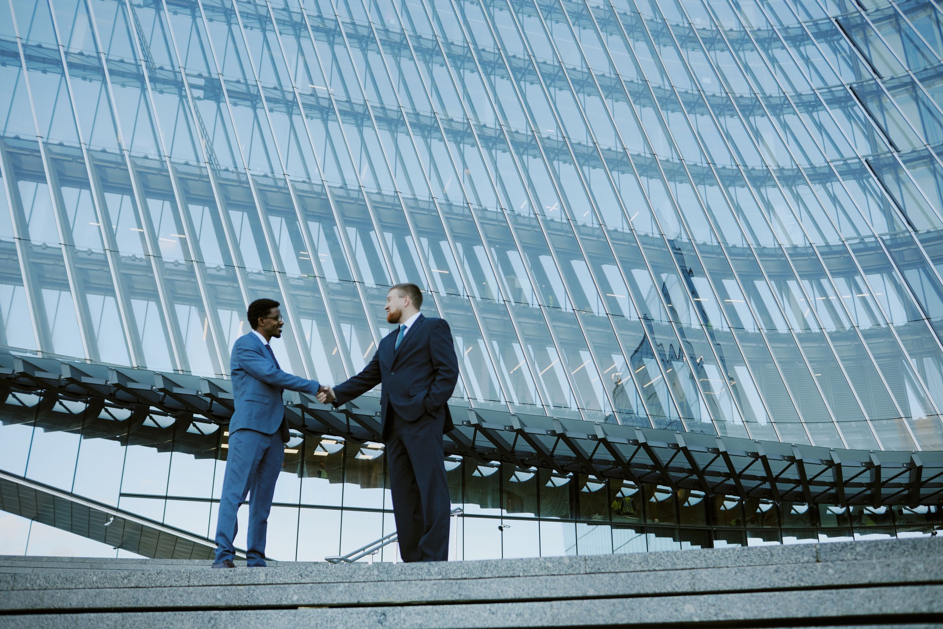 Two business professionals shaking hands to establish government contracting partnership